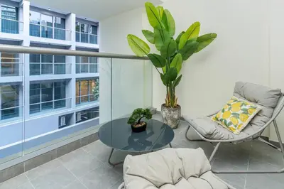 a balcony with a glass table and a chair and a plant at Designer Glam Studio Steps from Burj Khalifa in Dubai