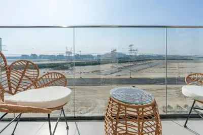 a group of chairs and a table in front of a window at Studio 12min from Burj Khalifa - Azizi Riviera 32 - Dubai in Dubai