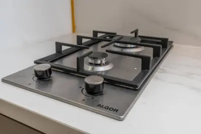 a stove top with four burners on a counter at Studio 12min from Burj Khalifa - Azizi Riviera 32 - Dubai in Dubai
