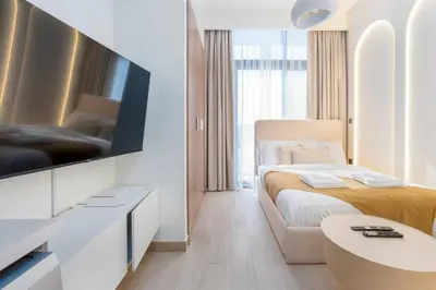 a hotel room with a bed and a tv at Studio 12min from Burj Khalifa - Azizi Riviera 32 - Dubai in Dubai