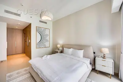 a white bedroom with a bed and a hallway at Act One Act Two by Emaar, Downtown Dubai in Dubai