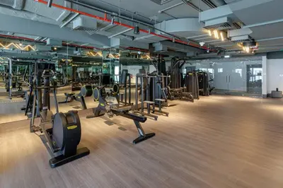 a gym with several treadmills and elliptical machines at Luxury Glam Studio Near Burj Khalifa Downtown in Dubai