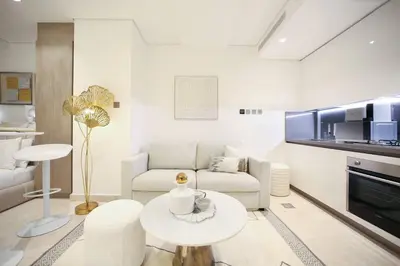 a white living room with a couch and a table at Luxury Glam Studio Near Burj Khalifa Downtown in Dubai
