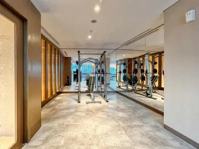 a gym with several treadmills and mirrors at GuestReady - Above the clouds at Opera Grand in Dubai