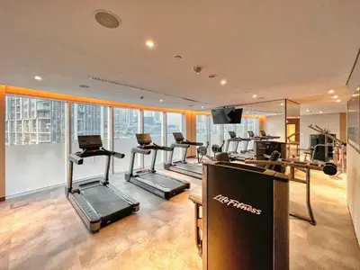 a gym with several tread machines in a room at GuestReady - Above the clouds at Opera Grand in Dubai