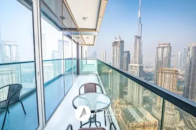 a balcony with a table and chairs on top of a building at 1BR Apartment in Paramount Midtown in Dubai