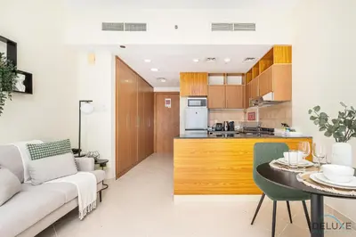 a kitchen and living room with a couch and a table at Comfortable Studio at Lago Vista A Dubai Production City by Deluxe Holiday Homes in Dubai
