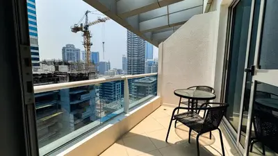 a balcony with a table and chairs and a view of the city at Dubai Marina (Marina Diamond 2) 1 Bedroom Apt. in Dubai
