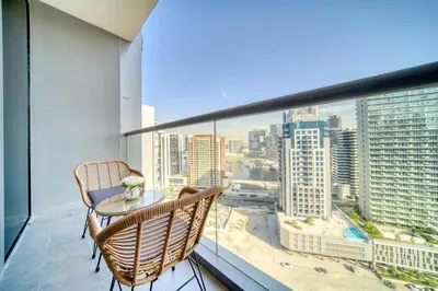 a balcony with a table and chairs and a view of the city at Canal-View Serenity: Modern Studio in Sterling in Dubai