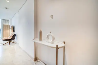 a room with a table with two candles and a chair at Canal-View Serenity: Modern Studio in Sterling in Dubai