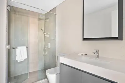 a white bathroom with a sink and a shower at ALiving Stylish 1BR Apartment I Fully Furnished with Balcony I Belgravia Square, JVC in Dubai