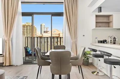 a kitchen and living room with a table and chairs at ALiving Stylish 1BR Apartment I Fully Furnished with Balcony I Belgravia Square, JVC in Dubai