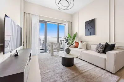 a living room with a white couch and a tv at Silkhaus Luxurious 1 BDR Stunning View in Dubai