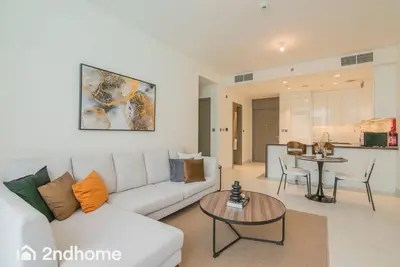 a living room with a white couch and a table at 2ndHome - District One Residences , Residence 14 in Dubai