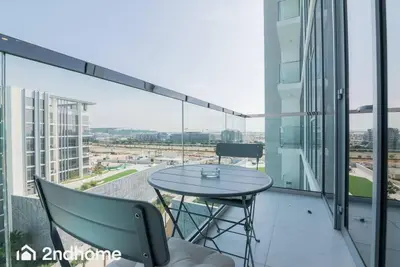 a glass balcony with a table and chairs on it at 2ndHome - District One Residences , Residence 14 in Dubai