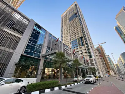 a large building with cars parked in front of it at ALiving Deluxe Studio I DAMAC Maison Prive, Business Bay -1204 in Dubai