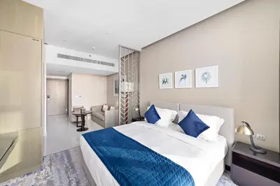 a bedroom with a large bed with a blue blanket at ALiving Deluxe Studio I DAMAC Maison Prive, Business Bay -1204 in Dubai