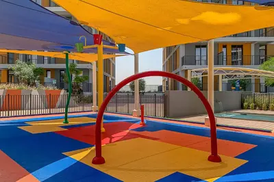 a playground in a pool with a yellow umbrella at Frank Porter - Noor 3 Midtown in Dubai