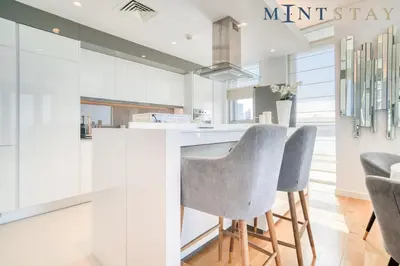 a kitchen with a counter and two stools at Bluewaters Residences 5, Bluewaters Island - Mint Stay in Dubai