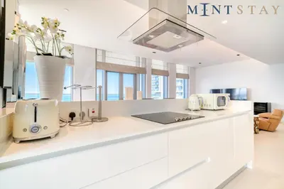 a kitchen with white counter tops and windows at Bluewaters Residences 5, Bluewaters Island - Mint Stay in Dubai