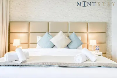 a bedroom with a white bed with blue pillows at Bluewaters Residences 5, Bluewaters Island - Mint Stay in Dubai