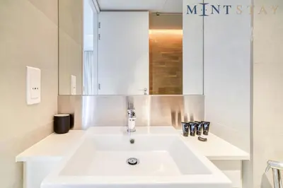 a bathroom with a white sink and a mirror at Bluewaters Residences 5, Bluewaters Island - Mint Stay in Dubai