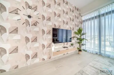 a living room with a tv and a wall at Decent 1BR at Azizi Riviera 17, Al Merkadh by Deluxe Holiday Homes in Dubai
