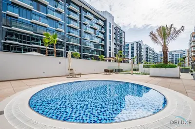 a large swimming pool in front of a building at Decent 1BR at Azizi Riviera 17, Al Merkadh by Deluxe Holiday Homes in Dubai