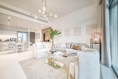 a living room with a couch and a table at Seaside Splendor: Luxe Retreat at Emaar Beachfront in Dubai