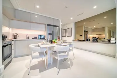 a kitchen with a white table and chairs in a kitchen at Seaside Splendor: Luxe Retreat at Emaar Beachfront in Dubai