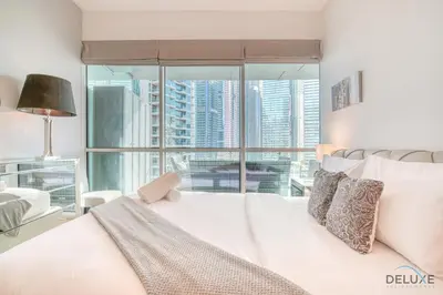 a bedroom with a white bed and a large window at Contemporary 1BR at Marina Terrace Tower Dubai Marina by Deluxe Holiday Homes in Dubai