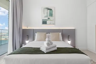 a bedroom with a large white bed with towels on it at Maison Privee - Upscale Apt w/ Open Sea and Bluewaters Vws in JBR in Dubai