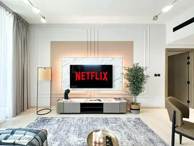 a living room with a netflix sign on the wall at Trophy - Stardust Sanctum Suites w Pool view in Heart of JVC in Dubai