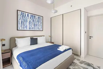 a bedroom with a large bed with a blue blanket at Silkhaus Beach Vibes with Harbor View & Private Beach in Dubai