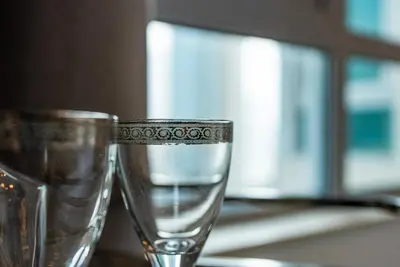 two glasses sitting on a table with water in them at Luxury 2BR Superior Apartment with Full Burj Khalifa and Dubai Mall Dancing Fountain View, Royal Tiffany in Dubai