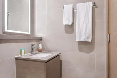 a bathroom with a sink and a mirror and towels at STAY BY LATINEM Luxury 2BR Holiday Home W1813 near Burj Khalifa in Dubai