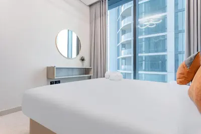 a bedroom with a large white bed and a window at STAY BY LATINEM Luxury 2BR Holiday Home W1813 near Burj Khalifa in Dubai