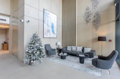 a living room with a christmas tree and chairs at STAY BY LATINEM Luxury 2BR Holiday Home W1813 near Burj Khalifa in Dubai