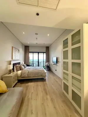a large bedroom with a bed and a television at Palm Apt. with Burj al arab view in Dubai