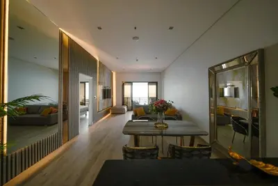 a dining room with a table and a living room at Palm Apt. with Burj al arab view in Dubai