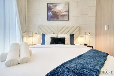 a bedroom with a large white bed with blue pillows at Sizeable 1BR at Azizi Riviera 35, Al Merkadh by Deluxe Holiday Homes in Dubai