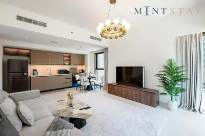 a living room with a couch and a tv at Burj Crown , Downtown Dubai - Mint Stay in Dubai