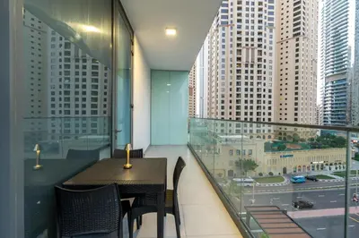 a table and chairs on a balcony with a view of a city at LIV Residence - Luxurious 2BR - Dubai Marina View - Marina Walk in Dubai