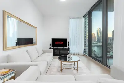 a living room with a white couch and a tv at LIV Residence - Luxurious 2BR - Dubai Marina View - Marina Walk in Dubai