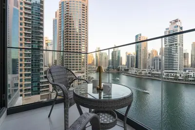 a table and chairs on a balcony with a view of a river at LIV Residence - Luxurious 2BR - Dubai Marina View - Marina Walk in Dubai