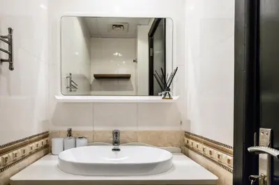 a bathroom with a white sink and a mirror at Trophy - Marina Urban Serenity Suite in Dubai