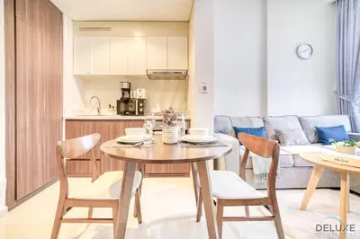 a kitchen and living room with a wooden table and chairs at Exclusive Deal, Chic 1BR at a Special Price by Deluxe Holiday Homes in Dubai