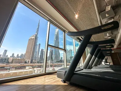 a gym with a view of the city from a window at Amazing Burj Khalifa Views with Direct Dubai Mall Access, 2BR Apartment in Downtown Dubai in Dubai