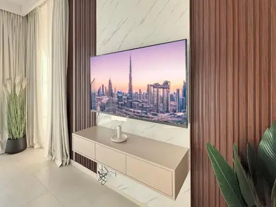 a living room with a tv on a wall at Amazing Burj Khalifa Views with Direct Dubai Mall Access, 2BR Apartment in Downtown Dubai in Dubai