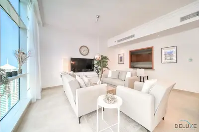 a living room with white furniture and a large window at Colossal 2BR at MAG 218 Dubai Marina by Deluxe Holiday Homes in Dubai